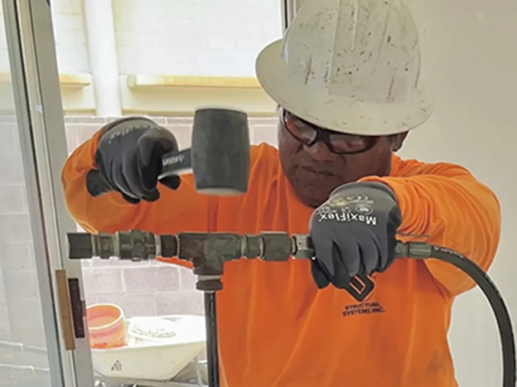 Structural Systems Hawaii technician installing grouting equipment for expansive clay soil stabilization.