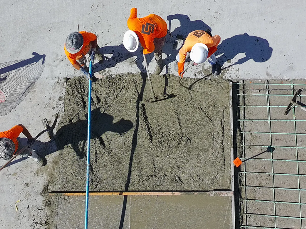 Structural Systems Hawaii crew finishing fresh concrete pour for spall repair section