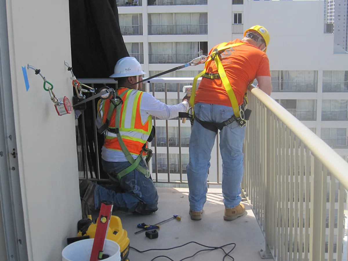 Structural Systems Hawaii technicians installing guardrail system on high-rise balcony railing