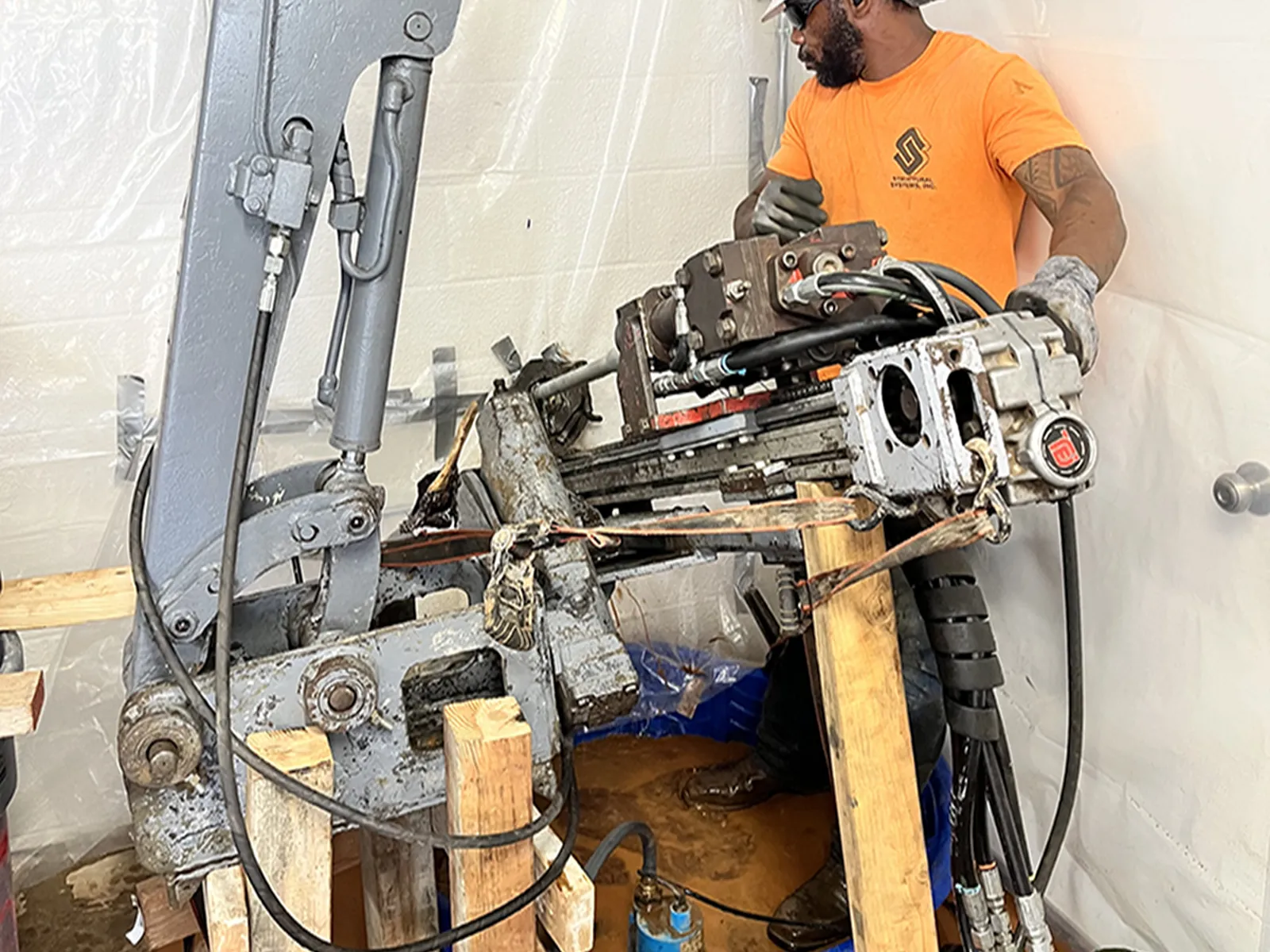 Structural Systems Hawaii technician operating hydraulic drill rig for micropile underpinning system installation