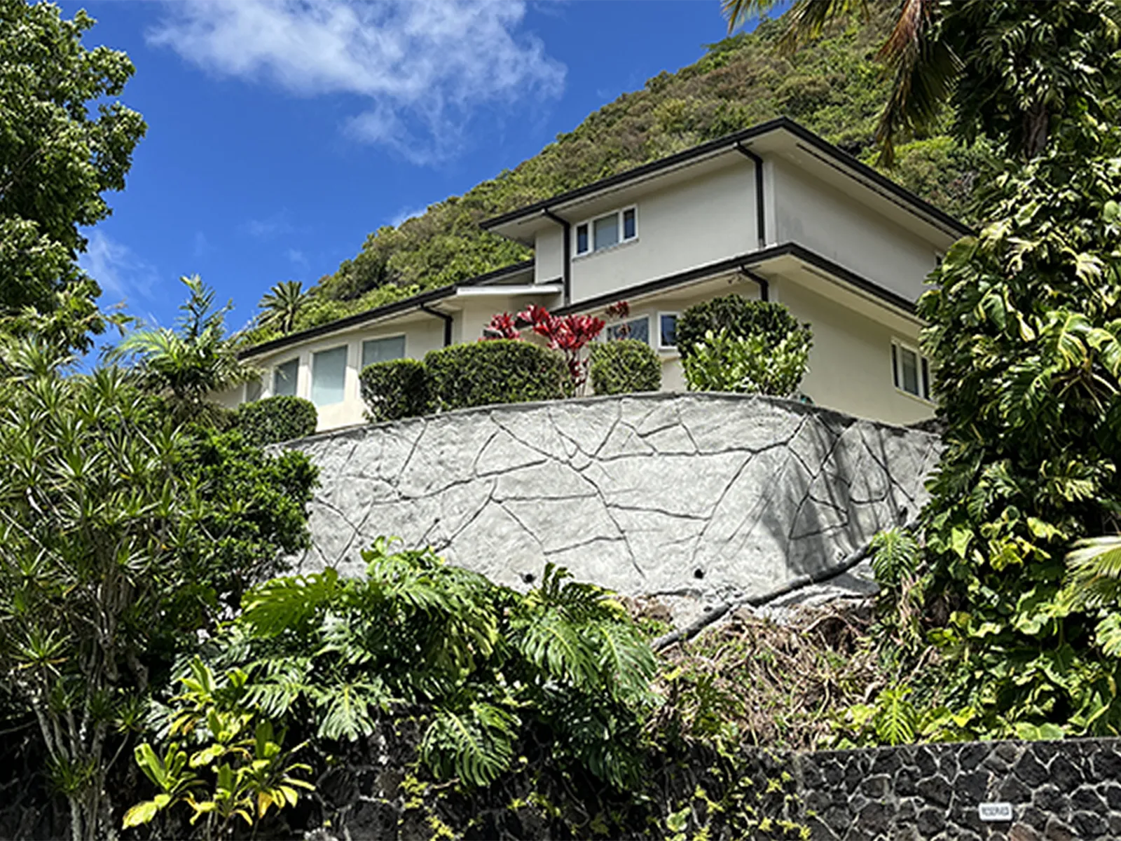 Structural Systems Hawaii cracked concrete retaining wall below hillside home before repair.
